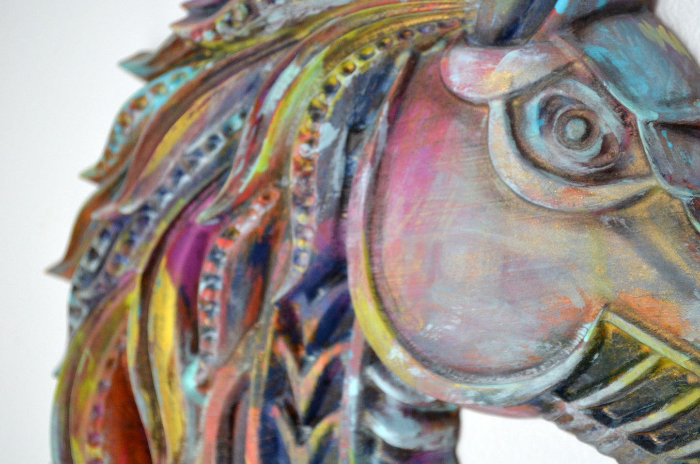 Colorful horse head sculpture with intricate details on a white background