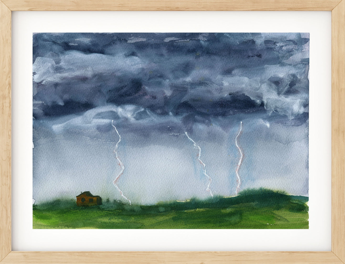A framed watercolor painting of a dramatic storm scene with dark gray clouds, multiple lightning bolts striking down, and a green field with a small house near the left side. The artwork is shown with a white mat and a light natural wood frame.
