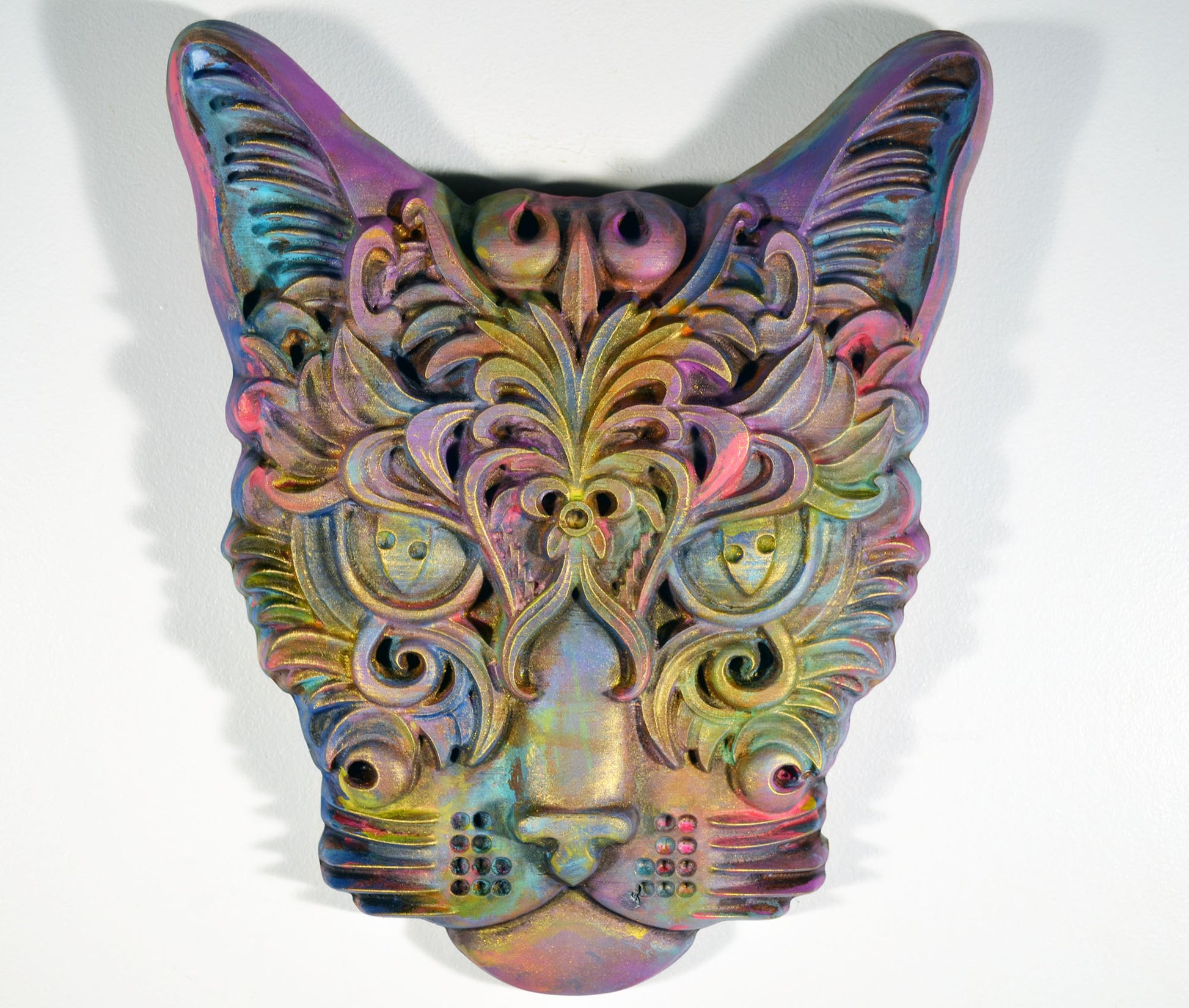 A hand-painted 3D wood carving of a cat with a vibrant, colorful design, finished with a wax topcoat and distressed for a decorative effect.