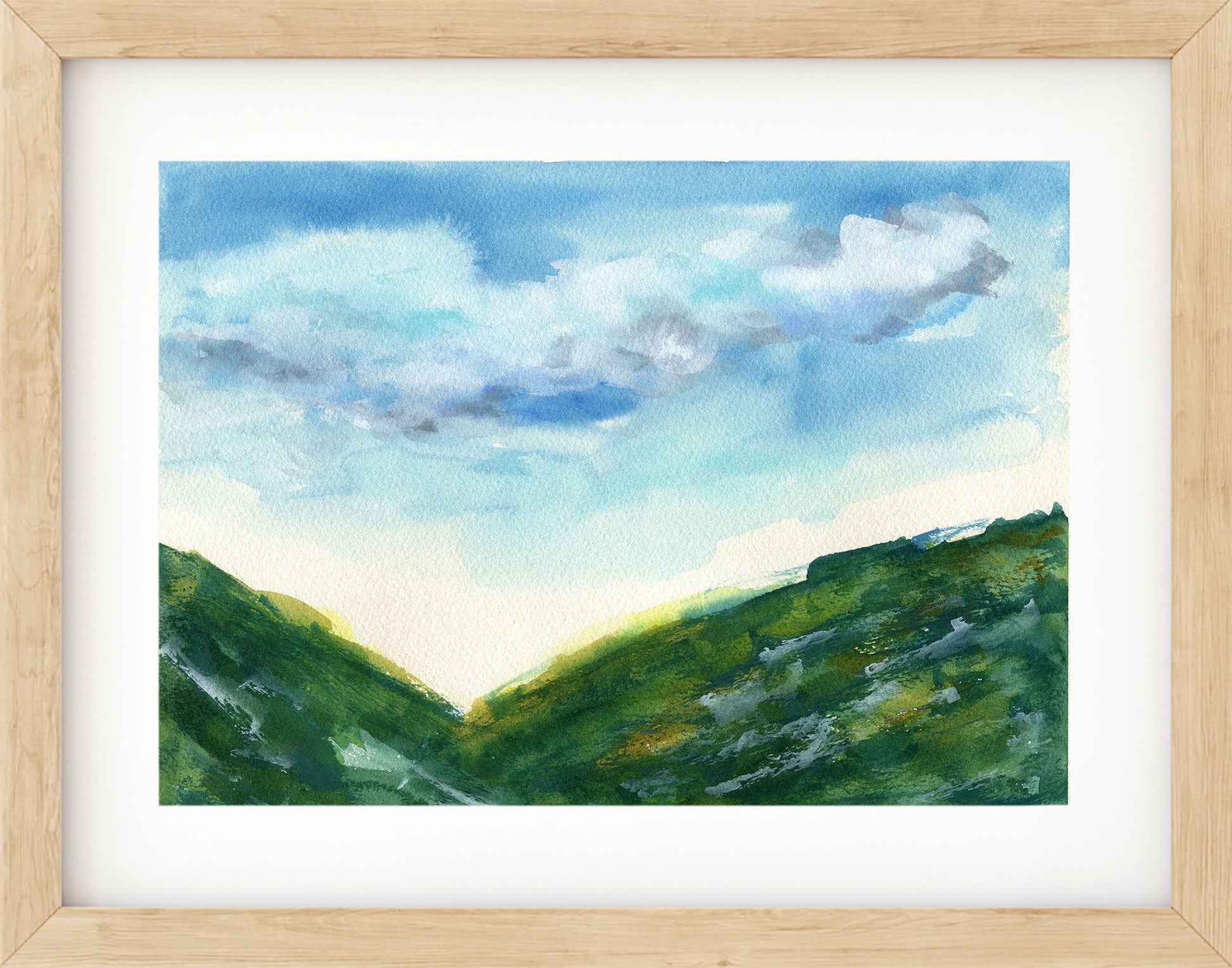 Framed painting of a landscape with green hills and a blue sky.