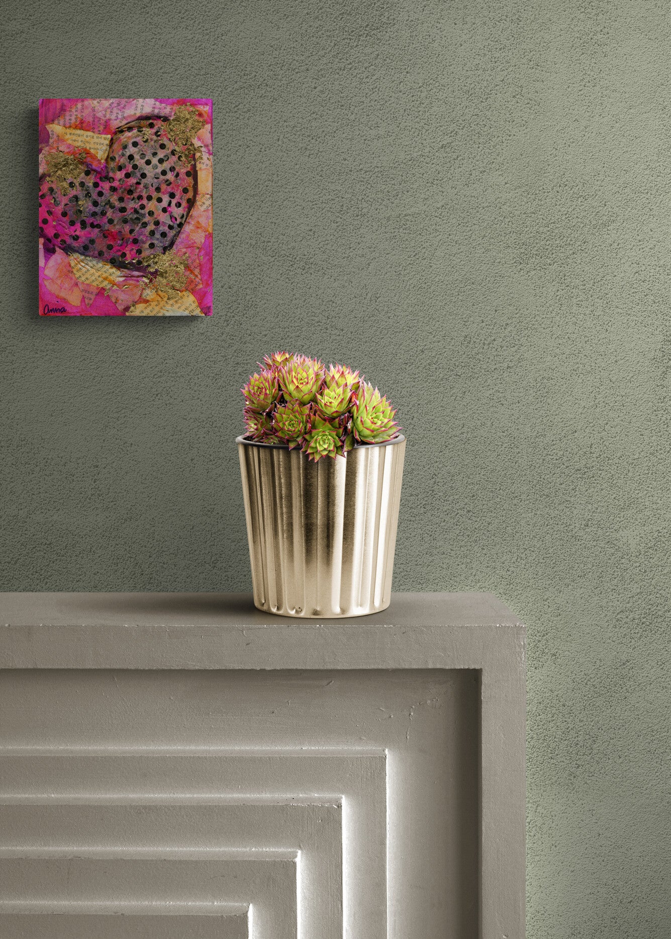 Decorative painting on a wall above a small potted plant on a ledge.