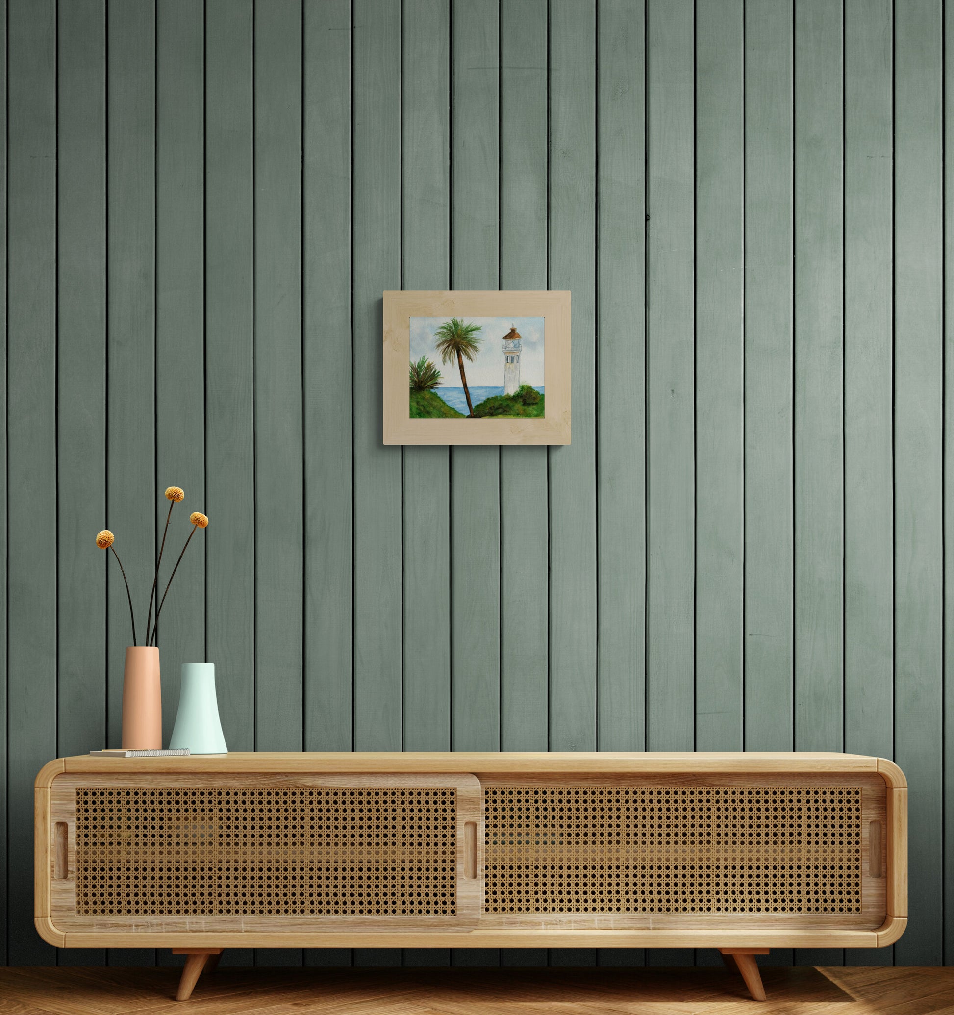 Wooden cabinet with decorative vases against a green paneled wall with a framed picture.