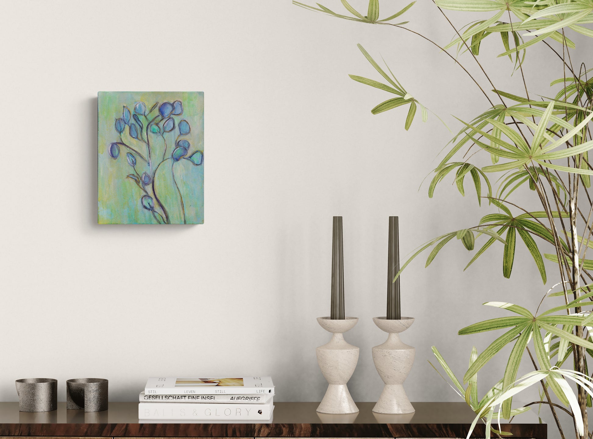 Decorative painting on a wall above a wooden surface with books and candle holders, next to a potted plant.