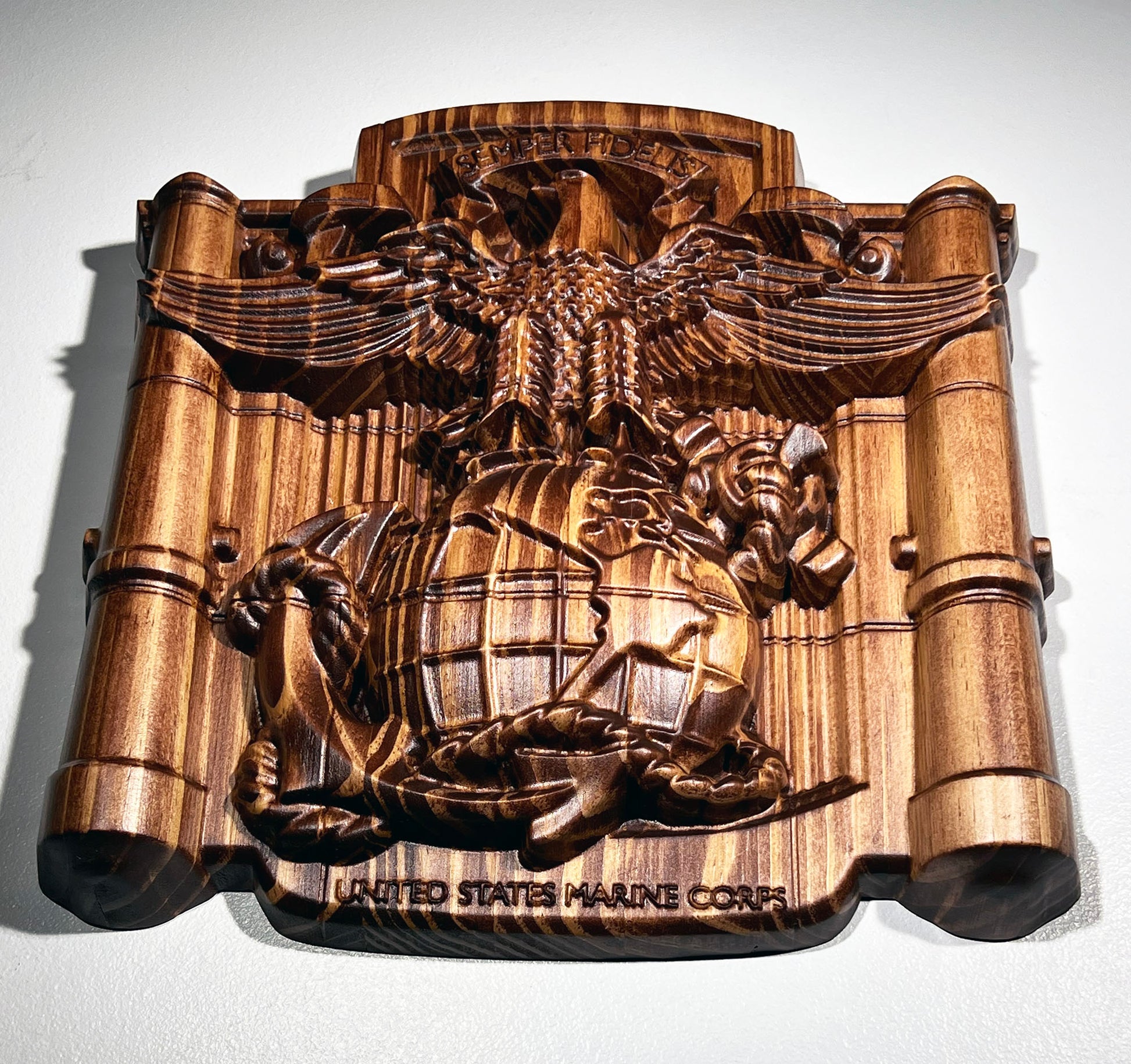 Wooden plaque with detailed emblem of the United States Marine Corps on a white background