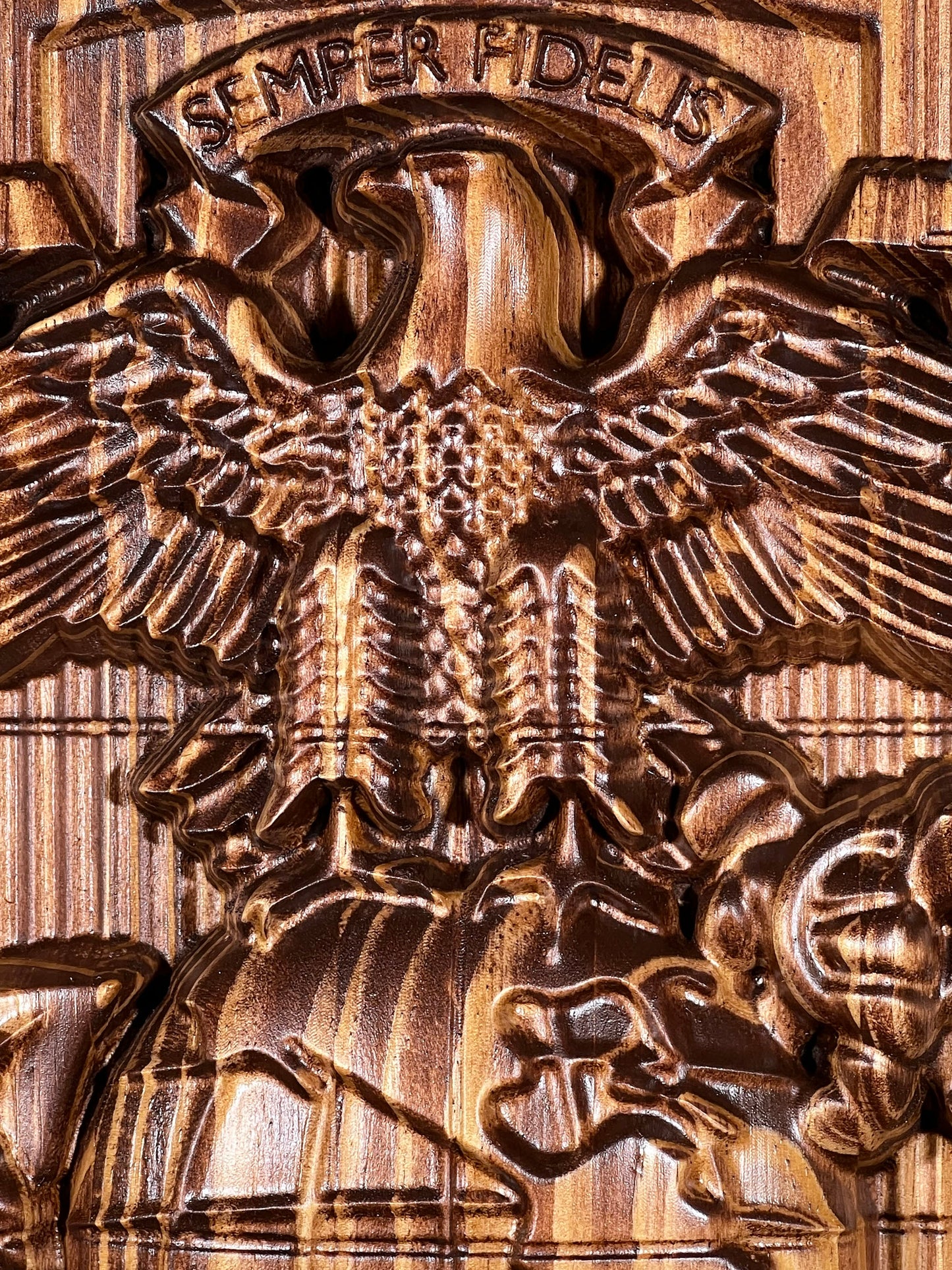 Bronze eagle emblem with 'Semper Fidelis' inscription on a wooden background