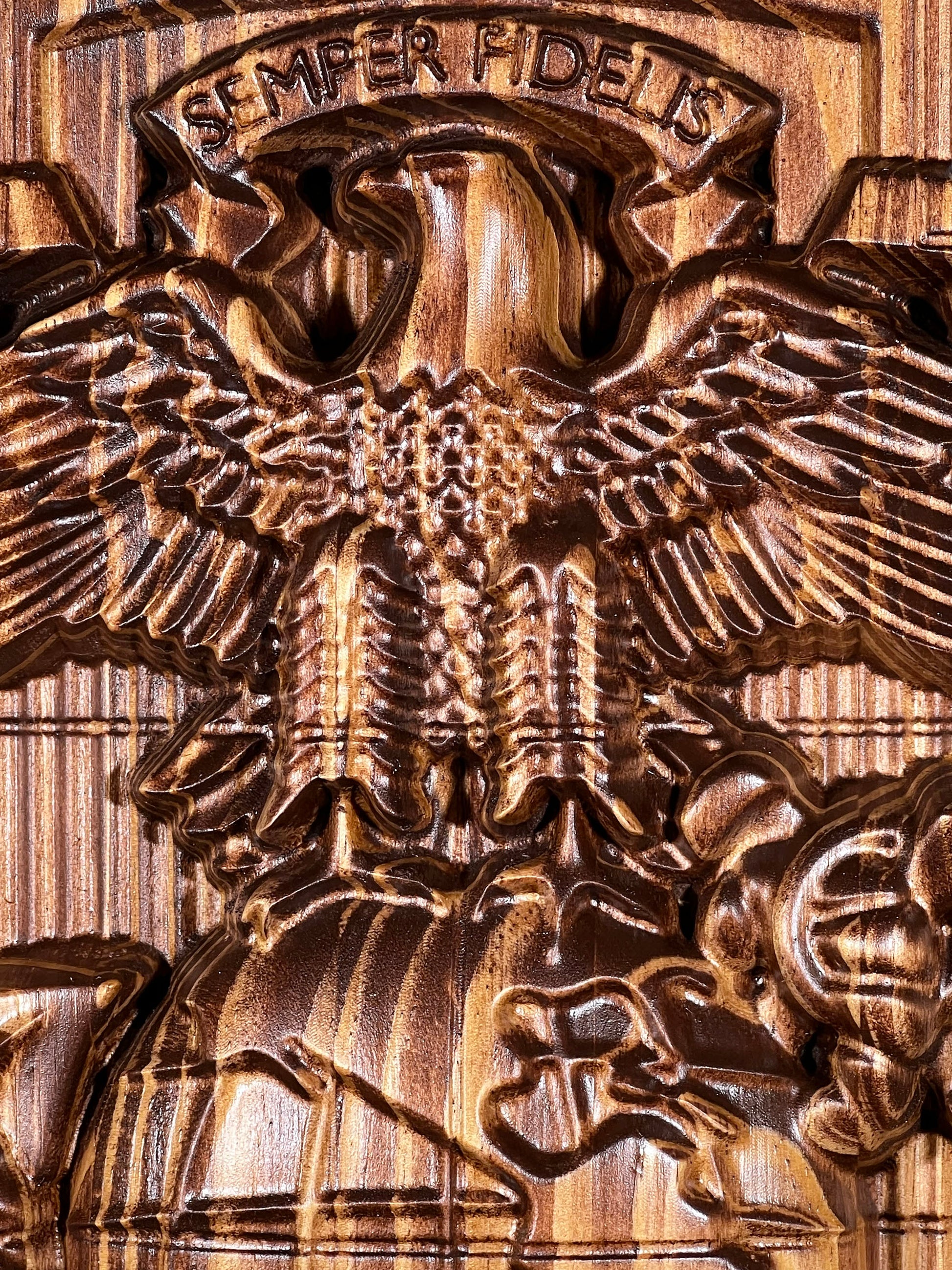 Bronze eagle emblem with 'Semper Fidelis' inscription on a wooden background