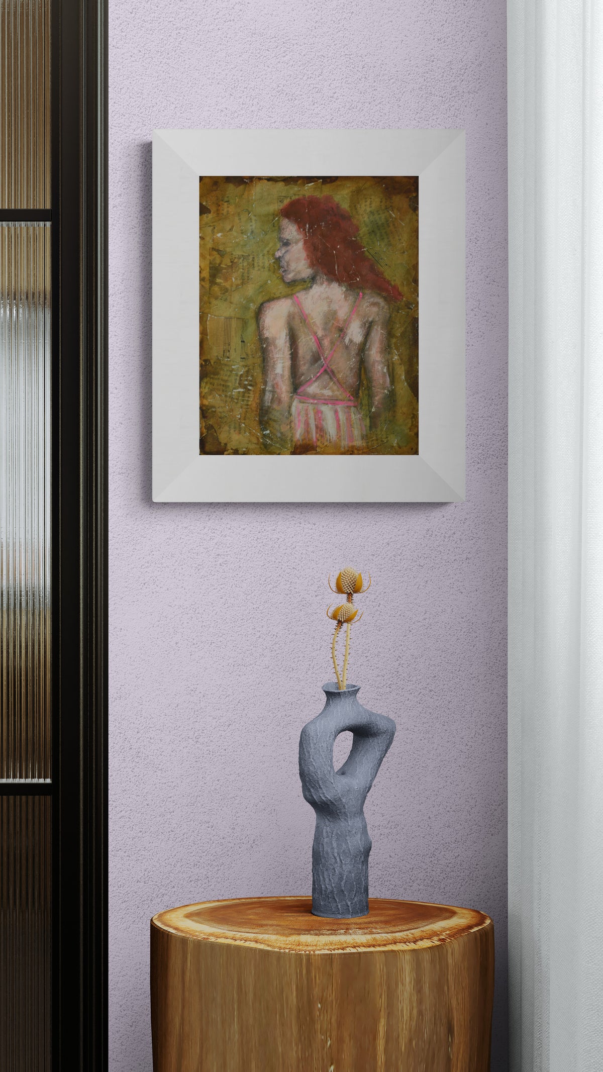 A framed art print depicting a woman with red hair from behind, hanging on a lavender wall above a wooden table with a gray sculptural vase.
